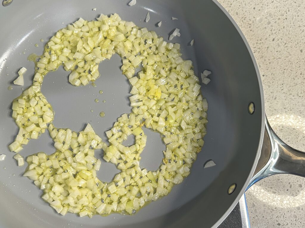 A non-stick skillet pan with sauteed and softened chopped onions 