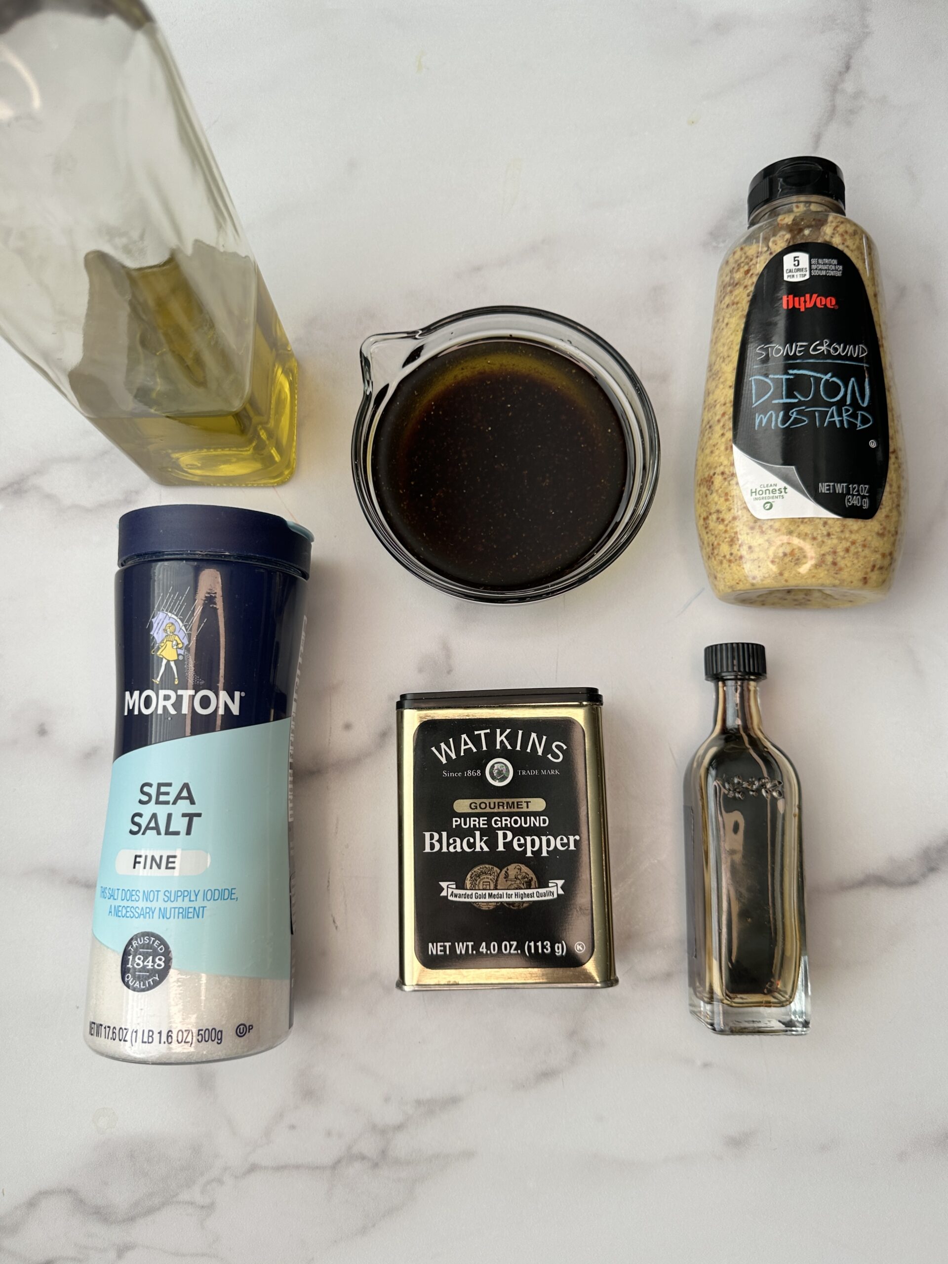 balsamic dressing ingredients: olive oil, balsamic vinegar, mustard, pepper, and salt.