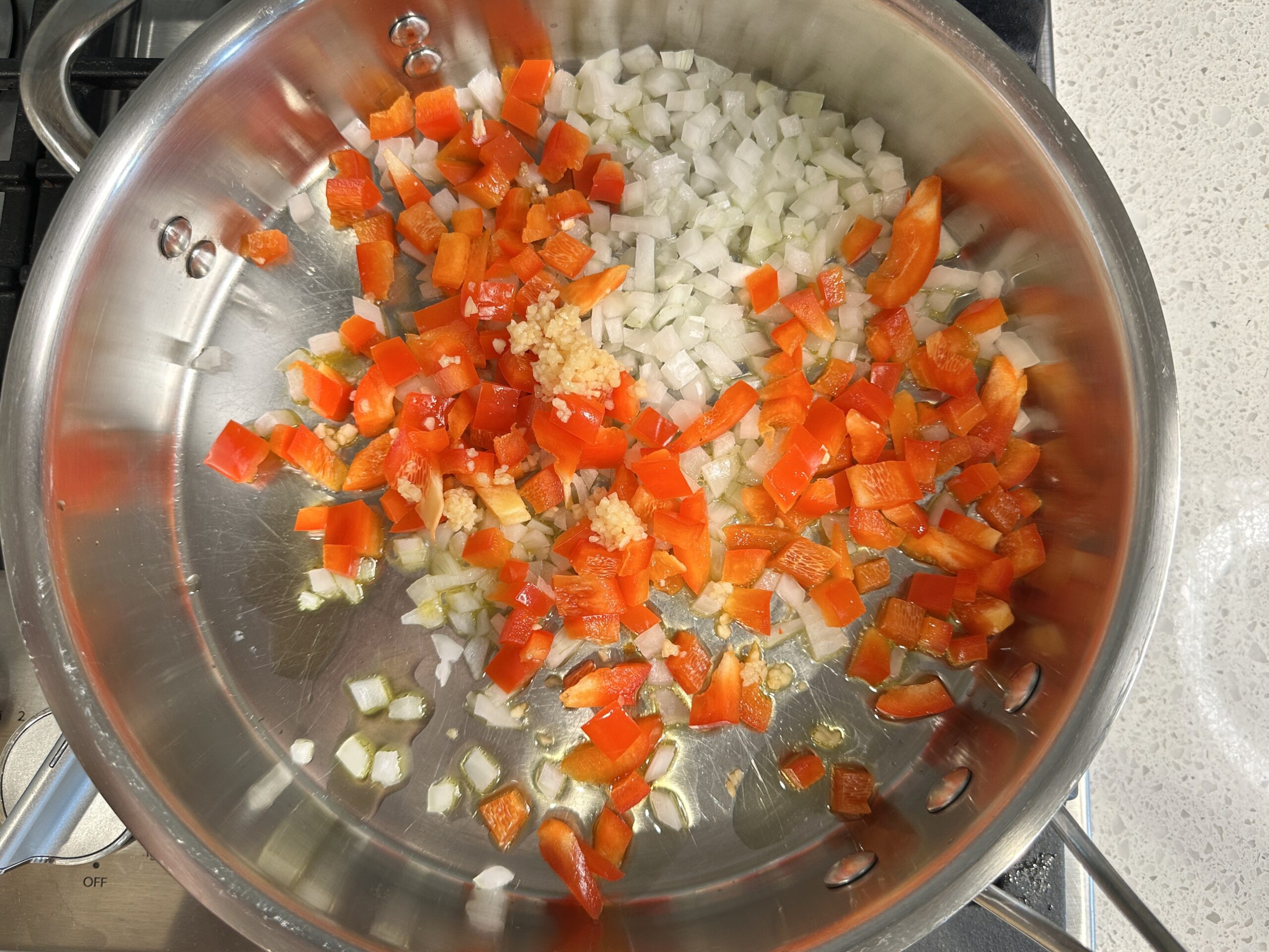 sauteed onions and red bell peppers in a large skillet