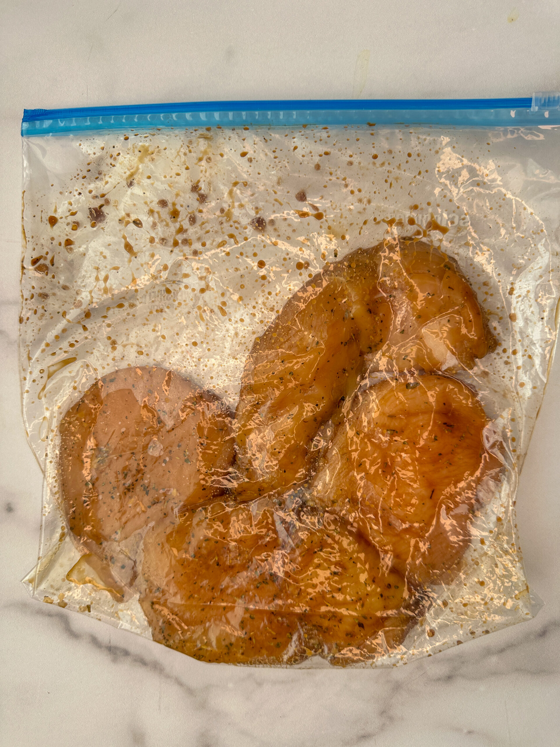 4 chicken breasts in marinade in plastic bag.