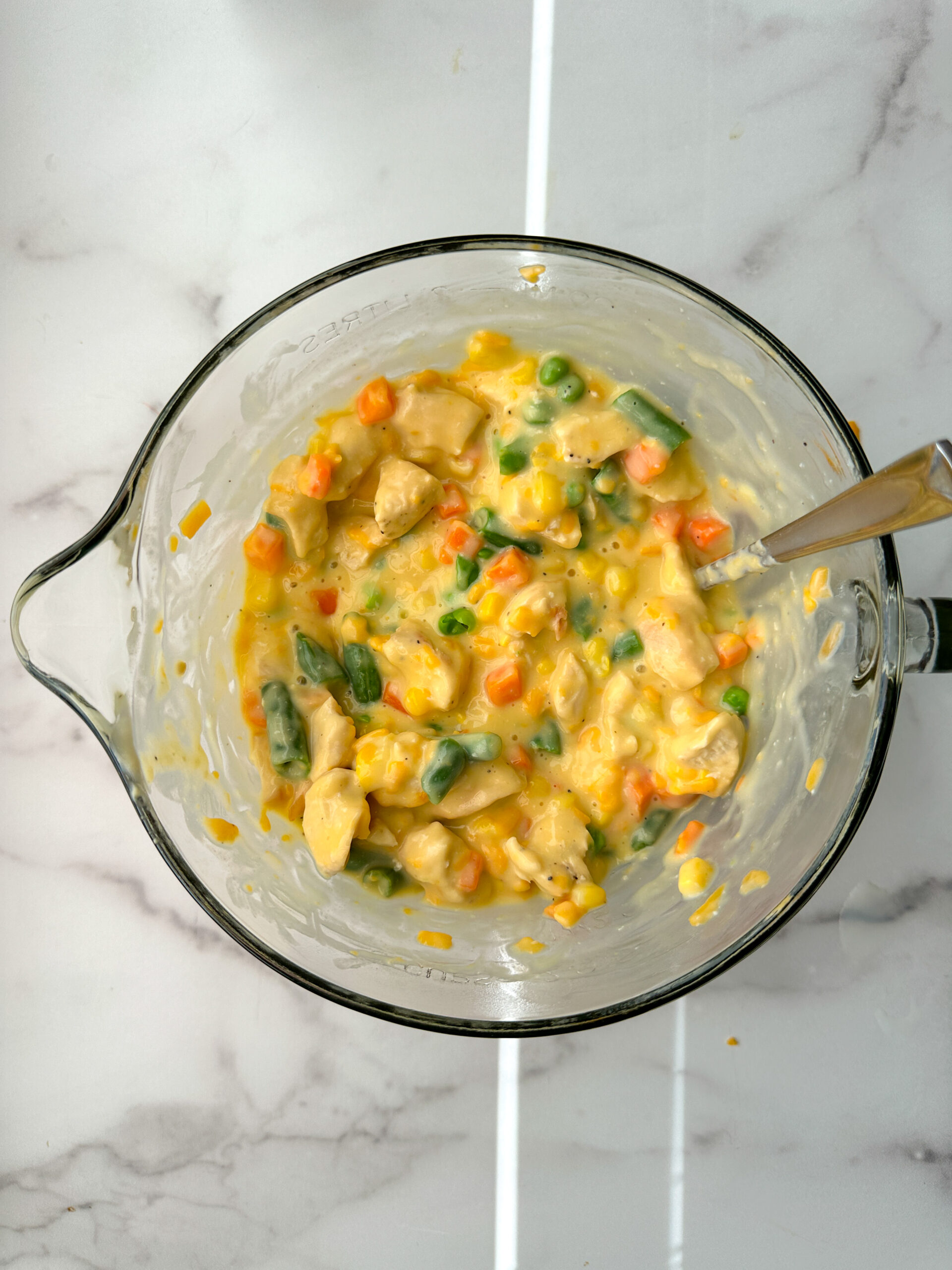 chicken pot pie filling in a mixing bowl: cream of chicken soup, mixed veggies, chopped cooked chicken, and cheddar cheese