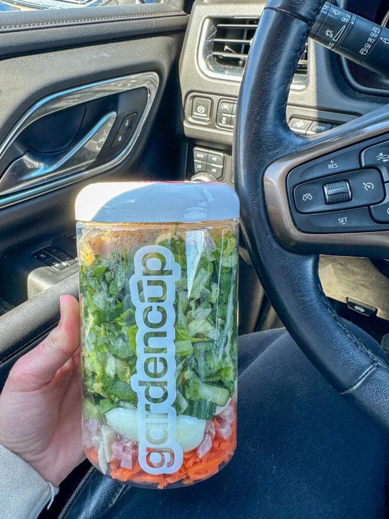 A clear jar with a salad in it
