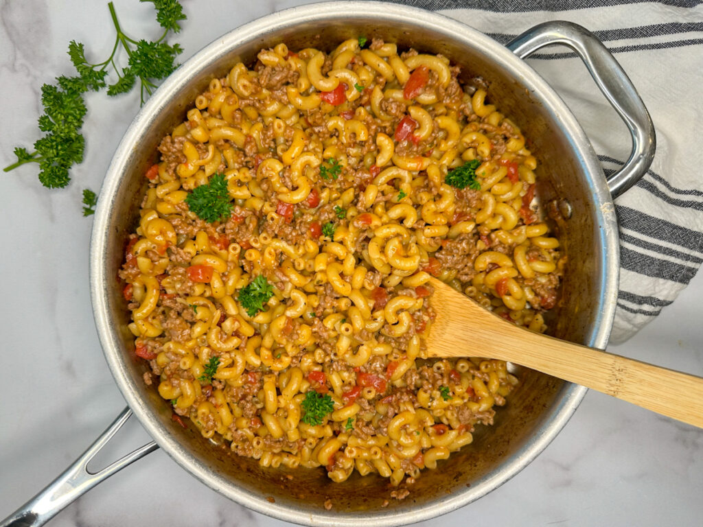 Healthier hamburger helper in a stainless steel skillet with pasta noodles and ground beef