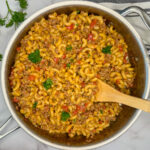 Healthier hamburger helper in a stainless steel skillet with pasta noodles and ground beef