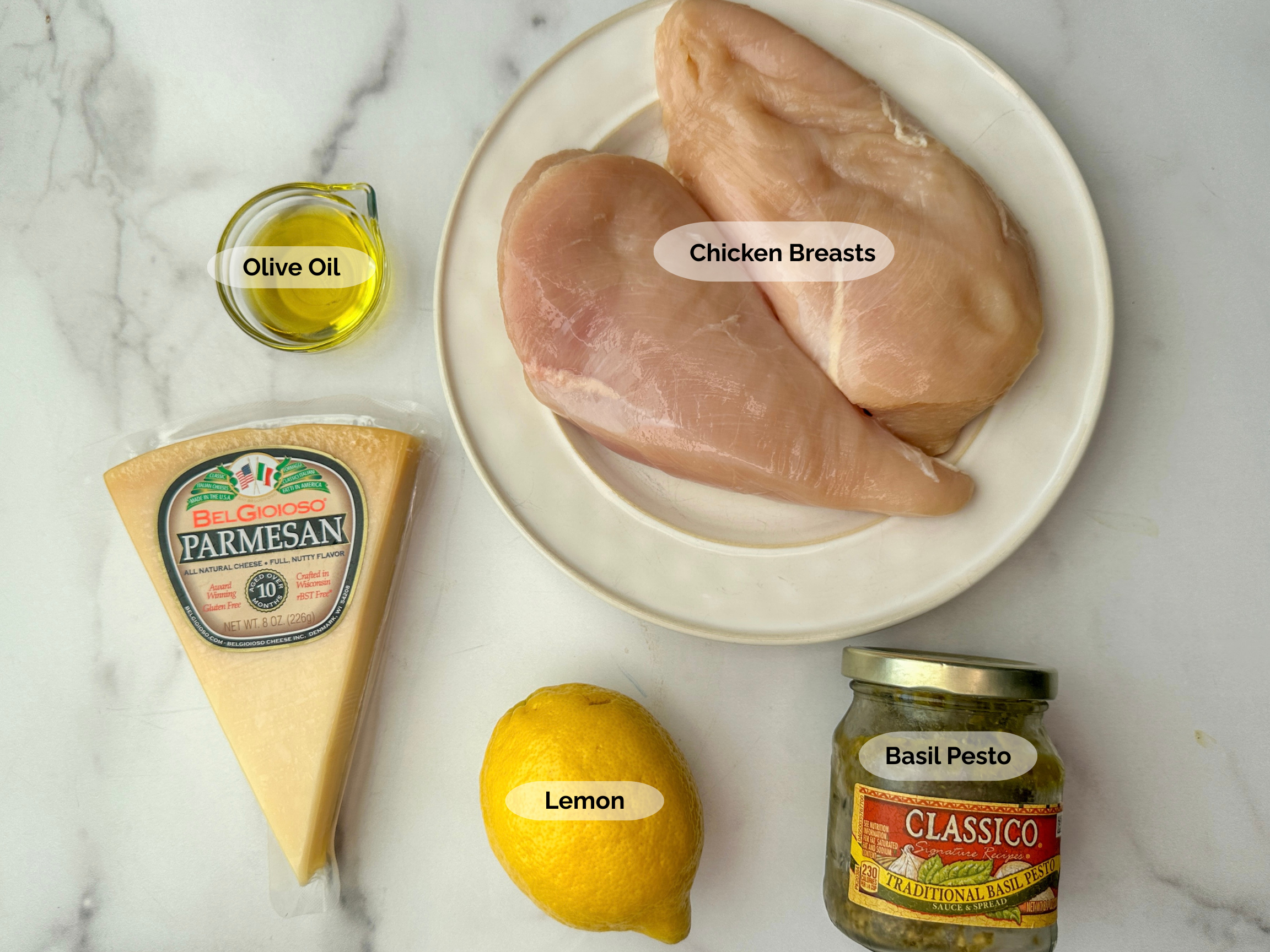 Grilled Lemon Pesto Chicken ingredients: olive oil, parmesan cheese, chicken breasts, lemon, basil pesto.