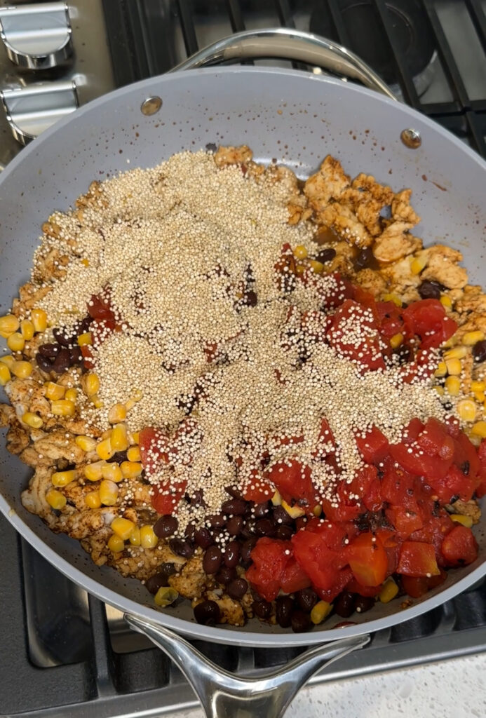 Black beans, quinoa, fire roasted tomatoes, and corn on top of cooked ground turkey