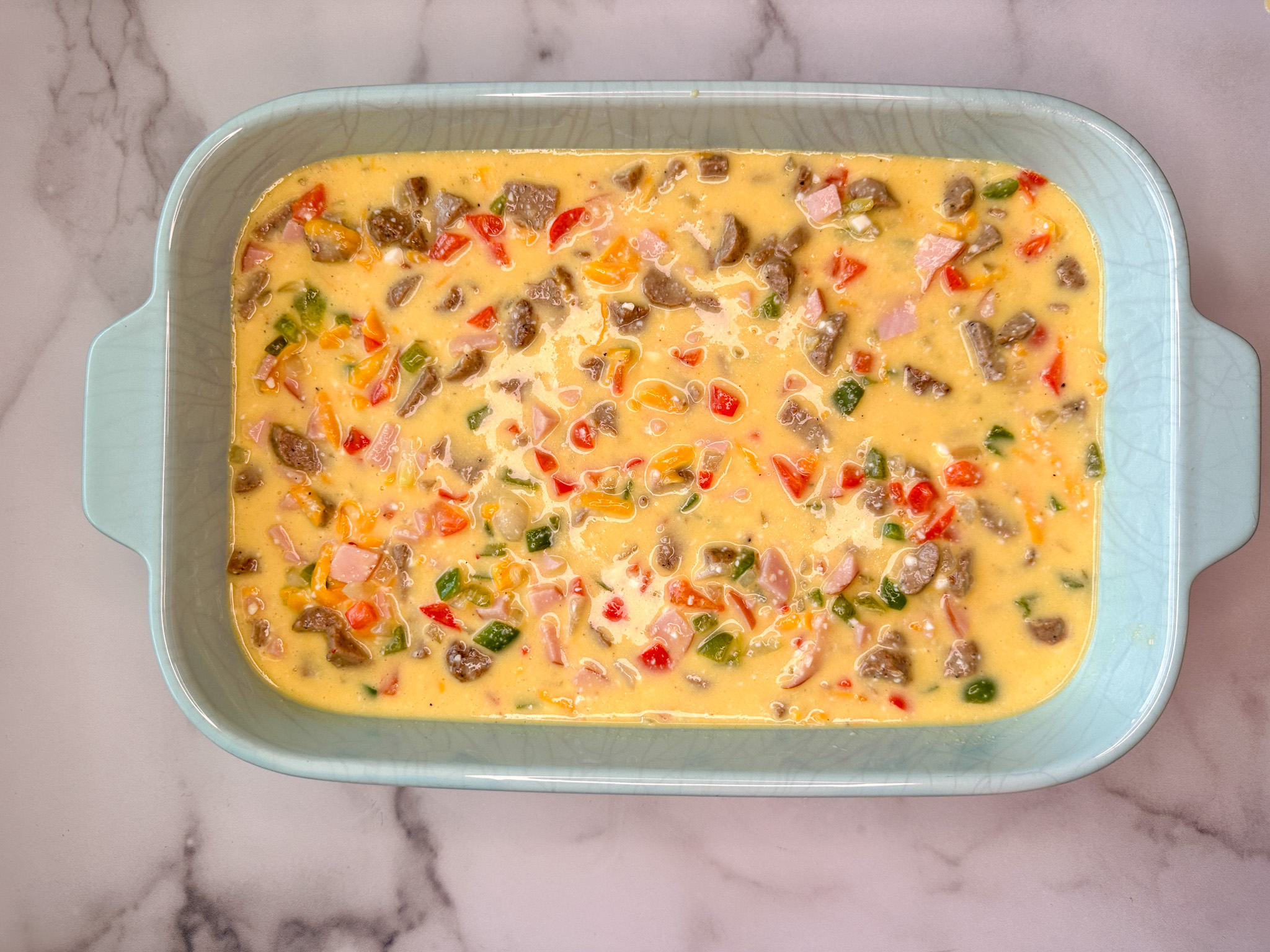 Egg and cottage cheese bake mixture poured into a 9x13 baking dish.