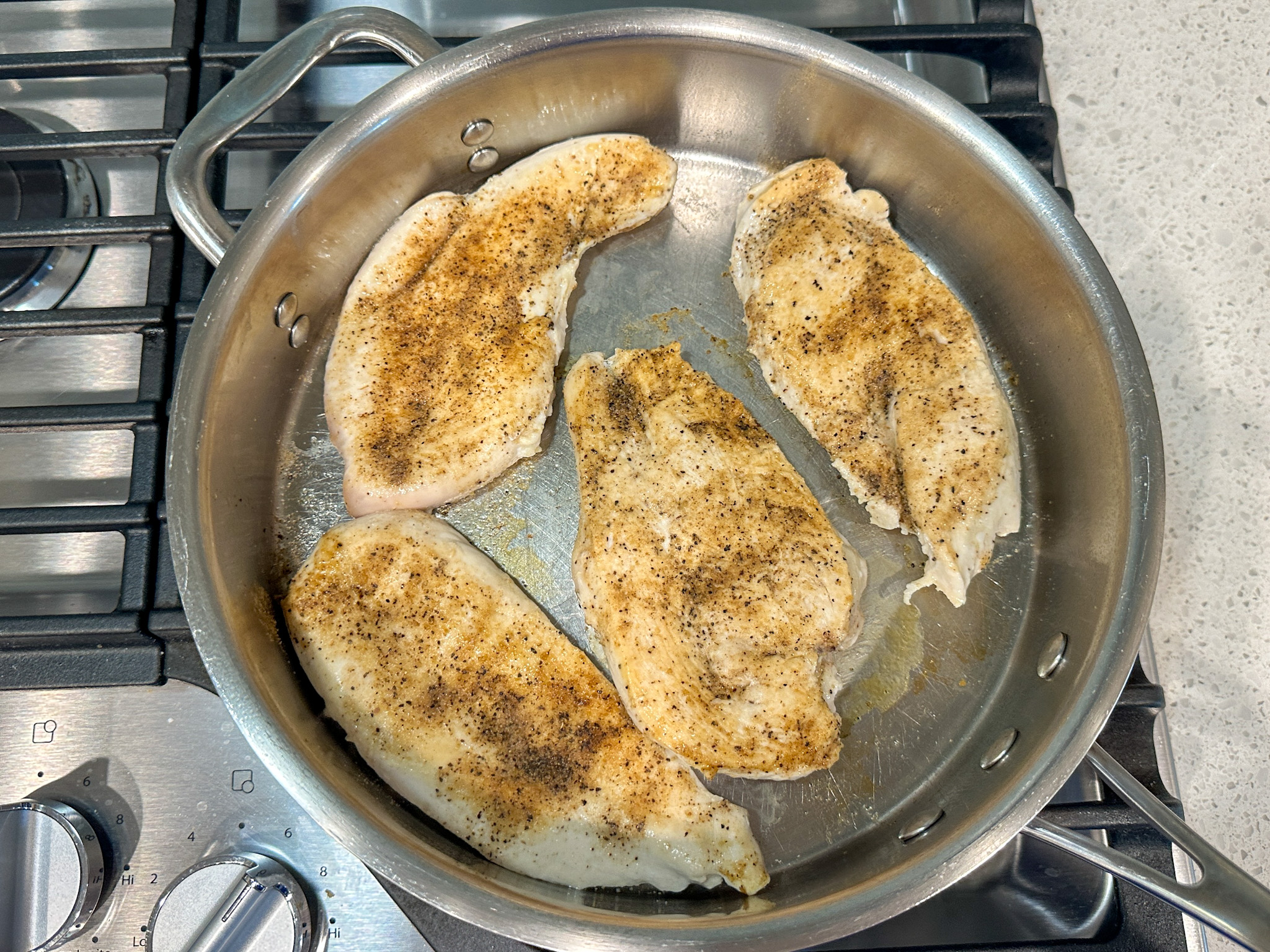 4 seared chicken breasts in a large skillet.