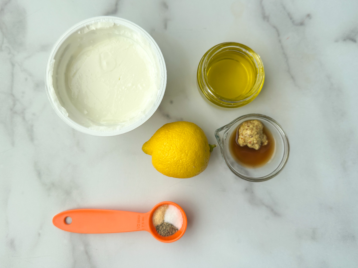 Plain, non-fat Greek yogurt, olive oil, one whole lemon, Worcestershire sauce with Dijon mustard, a measuring spoon of garlic powder, salt and pepper
