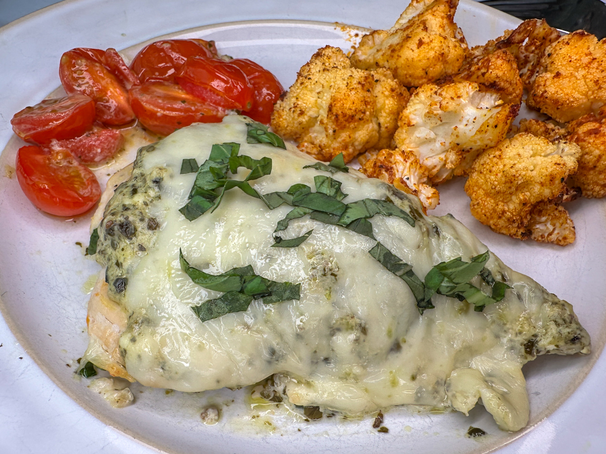 Chicken breast with creamy pesto topped with cheese and sliced basil