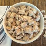 Protein puppy chow in a bowl with a white and blue striped napkin beside it