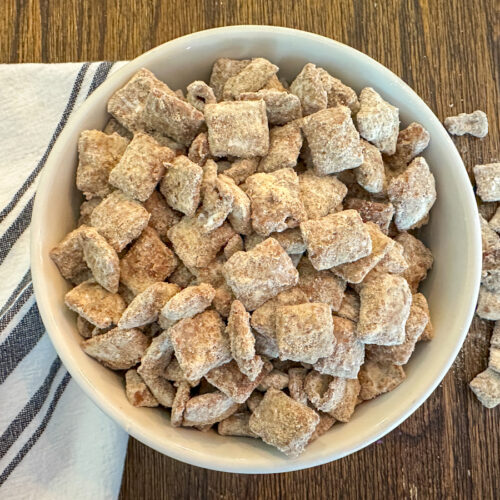 Protein puppy chow in a bowl with a white and blue striped napkin beside it