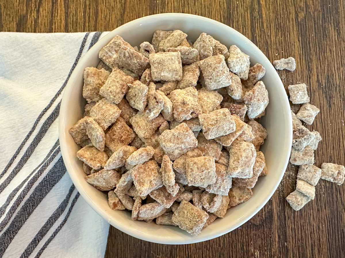 Protein puppy chow in a bowl with a white and blue striped napkin beside it