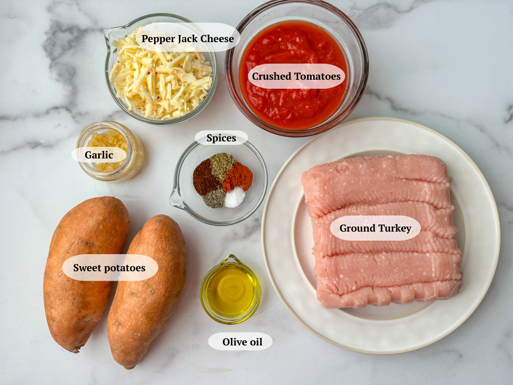 Turkey Taco Sweet Potato Ingredients: 2 large sweet potatoes, bowl of crushed tomatoes, bowl of shredded pepper jack cheese, 1 lb lean ground turkey, olive oil, spices, and minced garlic