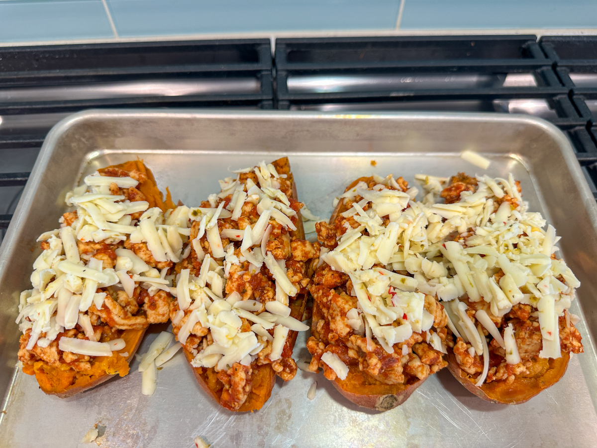 Turkey Taco Sweet Potatoes filled with the ground turkey and tomato filling and topped with shredded pepper jack cheese