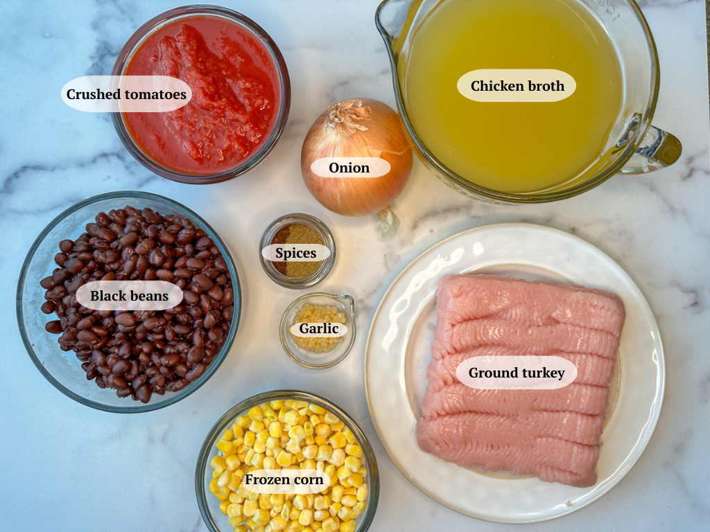 Turkey Taco Soup Ingredients: chicken broth, crushed tomatoes, black beans, onion, spices, garlic, ground turkey, and frozen corn
