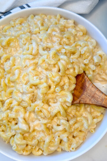 High Protein Mac and Cheese in a large bowl with a side of shredded white cheddar.