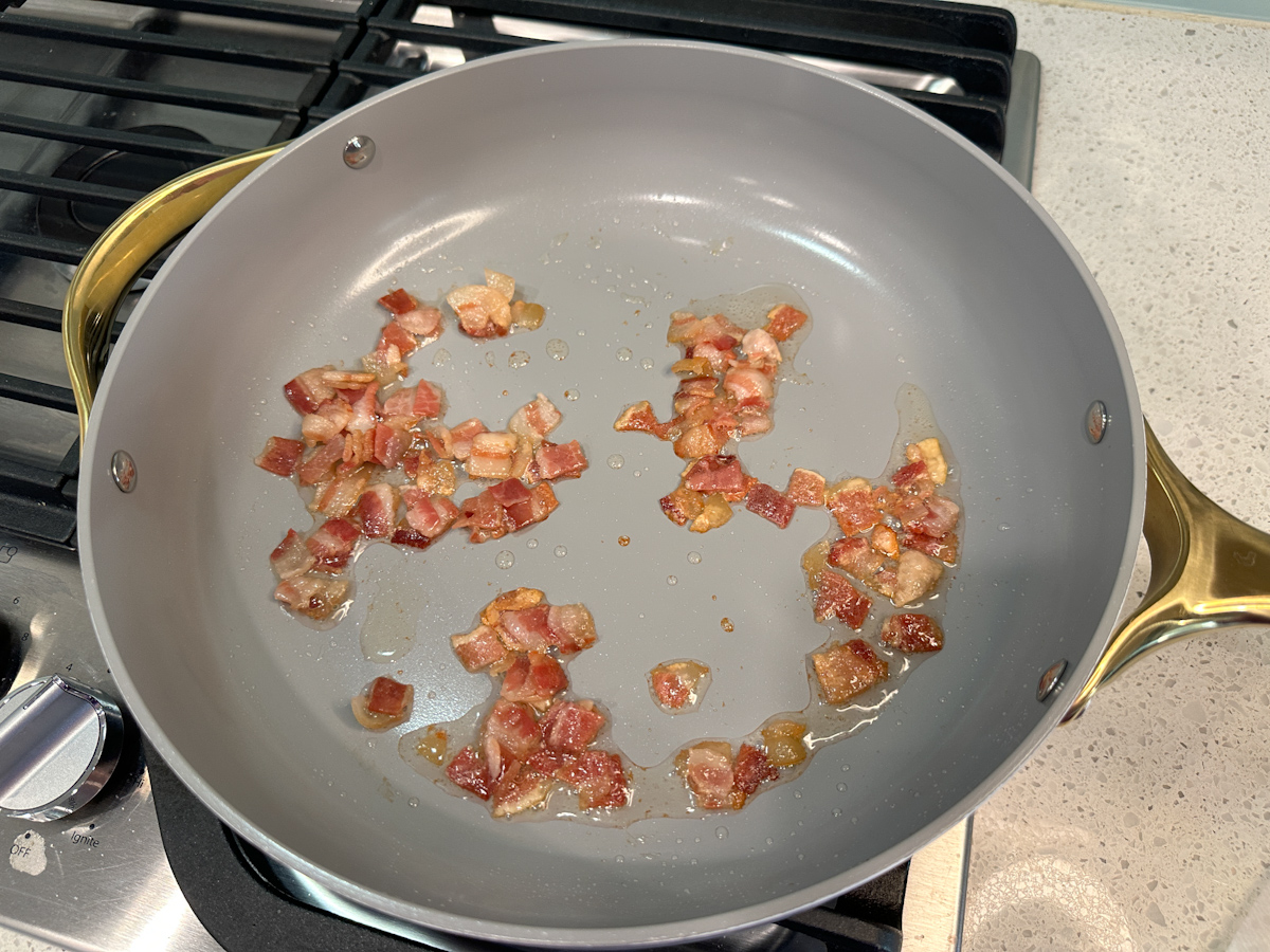 crumbled bacon bits cooking in a skillet