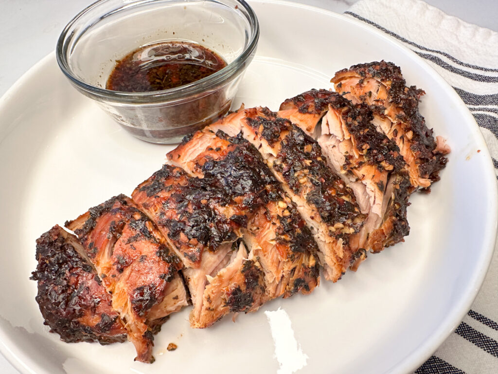 parmesan pork loin cooked, parmesan crusted, sliced on a large platter.