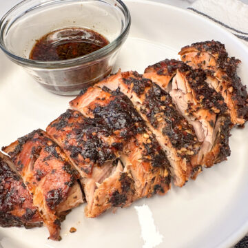 parmesan pork loin cooked, parmesan crusted, sliced on a large platter.