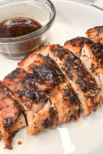 parmesan pork loin cooked, parmesan crusted, sliced on a large platter.