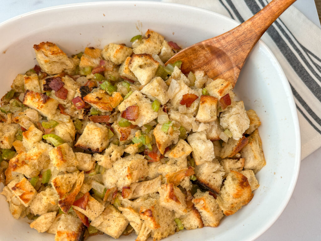 Sourdough stuffing baked in a casserole dish. Cubed pices of sourdough bread toasted with cooked bacon bits and sauteed onion and celery.