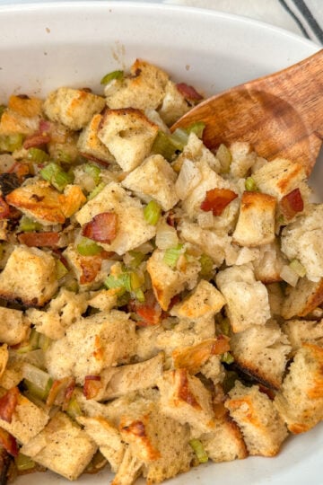 Sourdough stuffing baked in a casserole dish. Cubed pieces of sourdough bread toasted with cooked bacon bits and sauteed onion and celery.