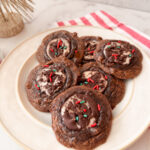 Fudgy Peppermint Brownie Cookies - 6 baked cookies on a plate topped with red and green sprinkles.