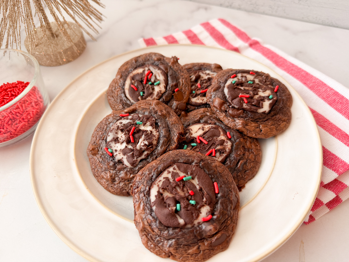 Fudgy Peppermint Brownie Cookies - 6 baked cookies on a plate topped with red and green sprinkles.