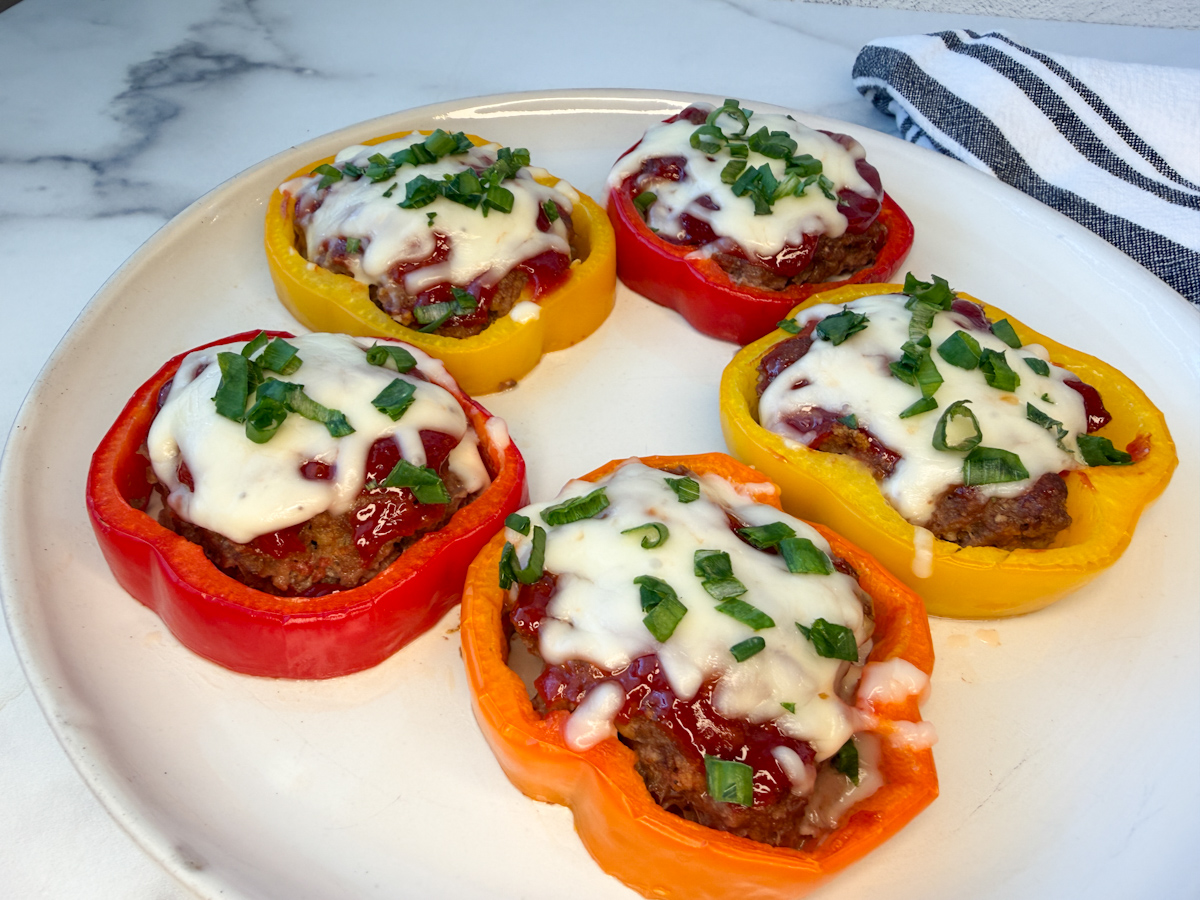 5 individual bell pepper meatloafs. Bell pepper rings filled with a meatloaf and topped with melted cheese and sliced green onions.