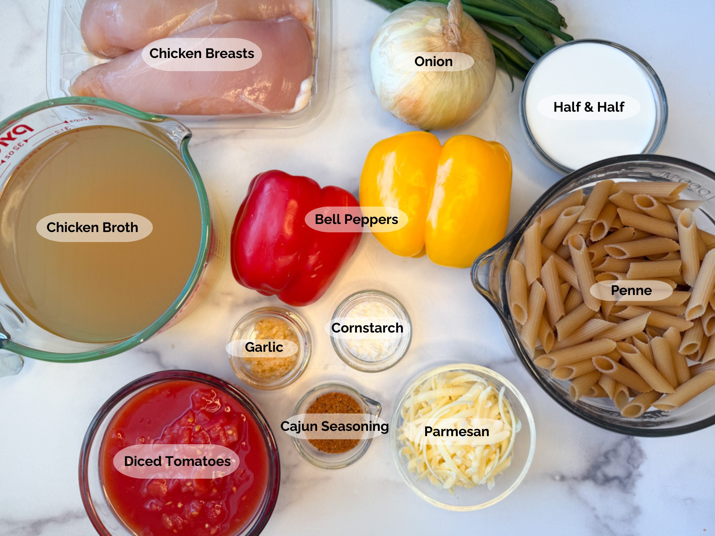 Cajun Chicken Pasta ingredients: chicken broth, chicken breasts, red and yellow bell peppers, onion, half and half, green onions, penne pasta, cornstarch, garlic, Cajun seasoning, petite diced tomatoes, and parmesan.