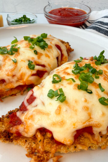 Air Fryer Chicken Parmesan: 2 breaded chicken breasts topped with marinara and melted mozzarella cheese.