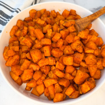 air fryer sweet potatoes in a large white serving bowl