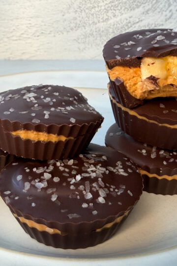 6 healthy peanut butter cups. One has a bite taken out of it.