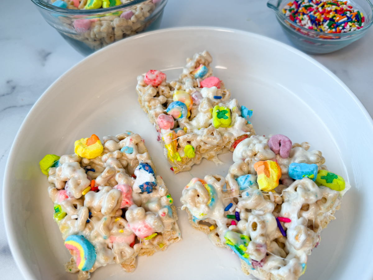 3 rice krispie treats made out of lucky charms with bright marshmallows on top. 
