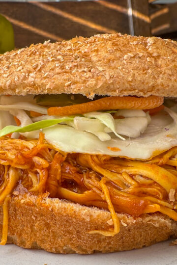 shredded bbq chicken topped with cole slaw and a whole wheat bun