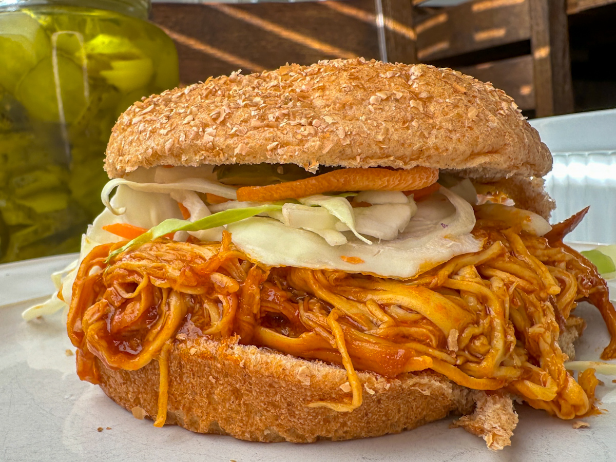 Shredded BBQ Chicken sandwich topped with cole slaw and a whole wheat bun