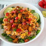 Street Corn Chicken Rice Bowl with lettuce, rice, grilled chicken, chopped tomatoes, corn, and peppers.