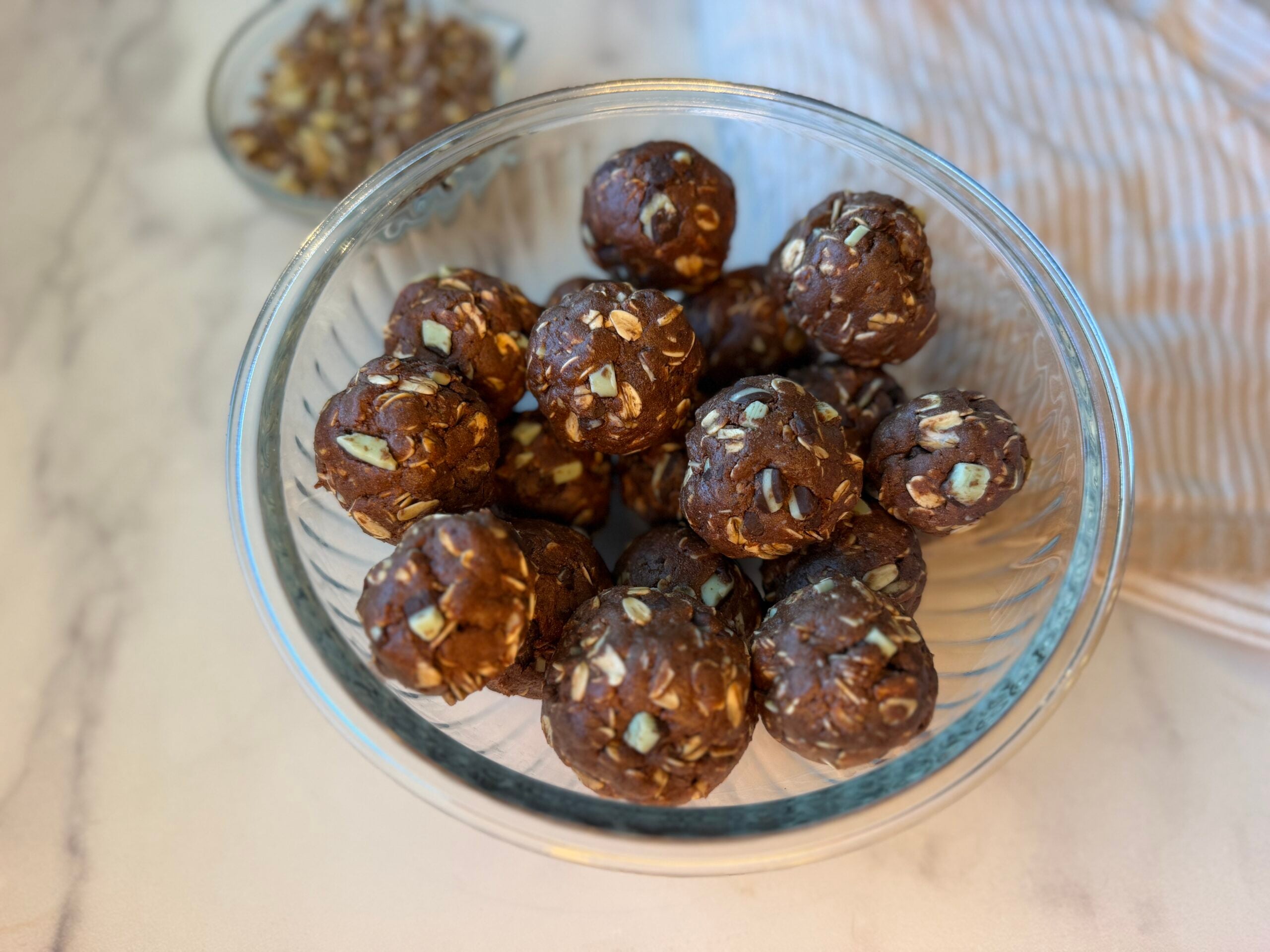 Mint chocolate protein balls rolled with about 15 balls in a clear bowl.