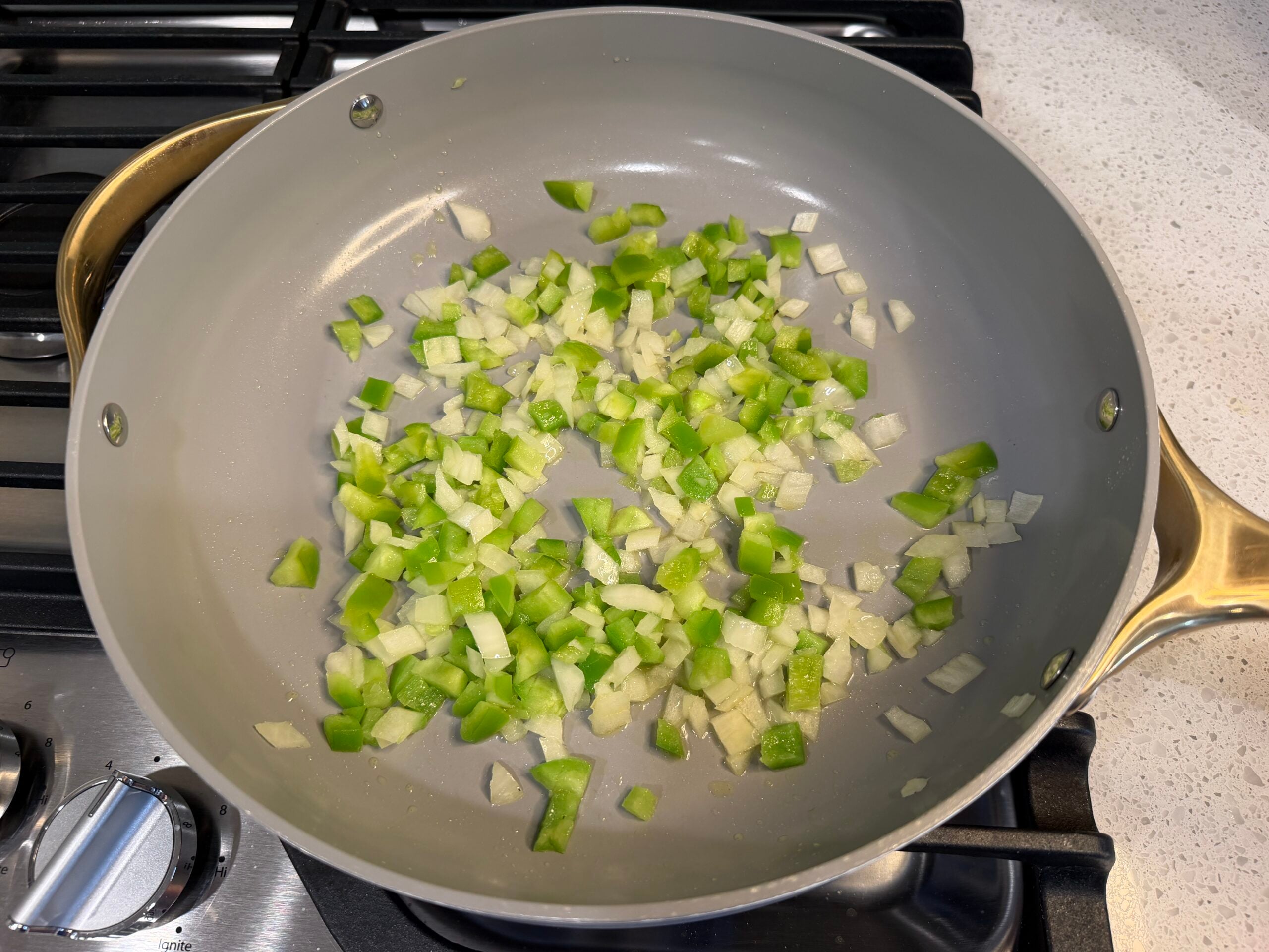 Onion and green pepper sauteing in a large skillet