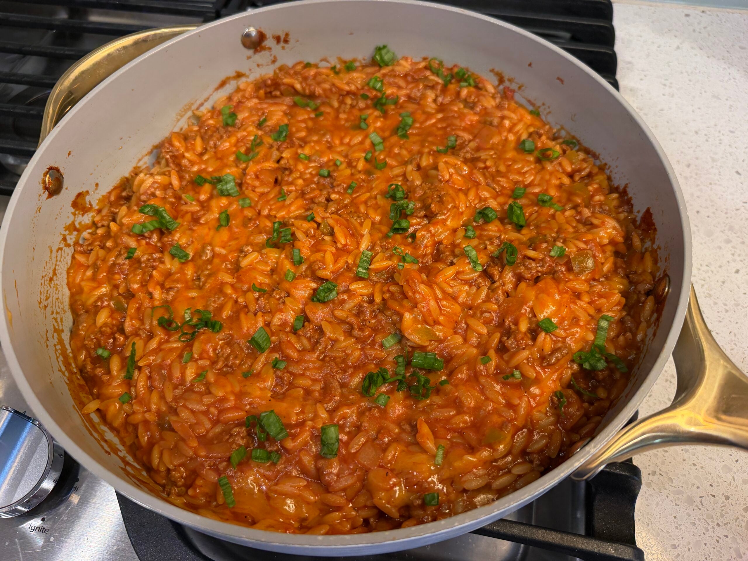Sloppy joe orzo skillet topped with melted cheddar cheese