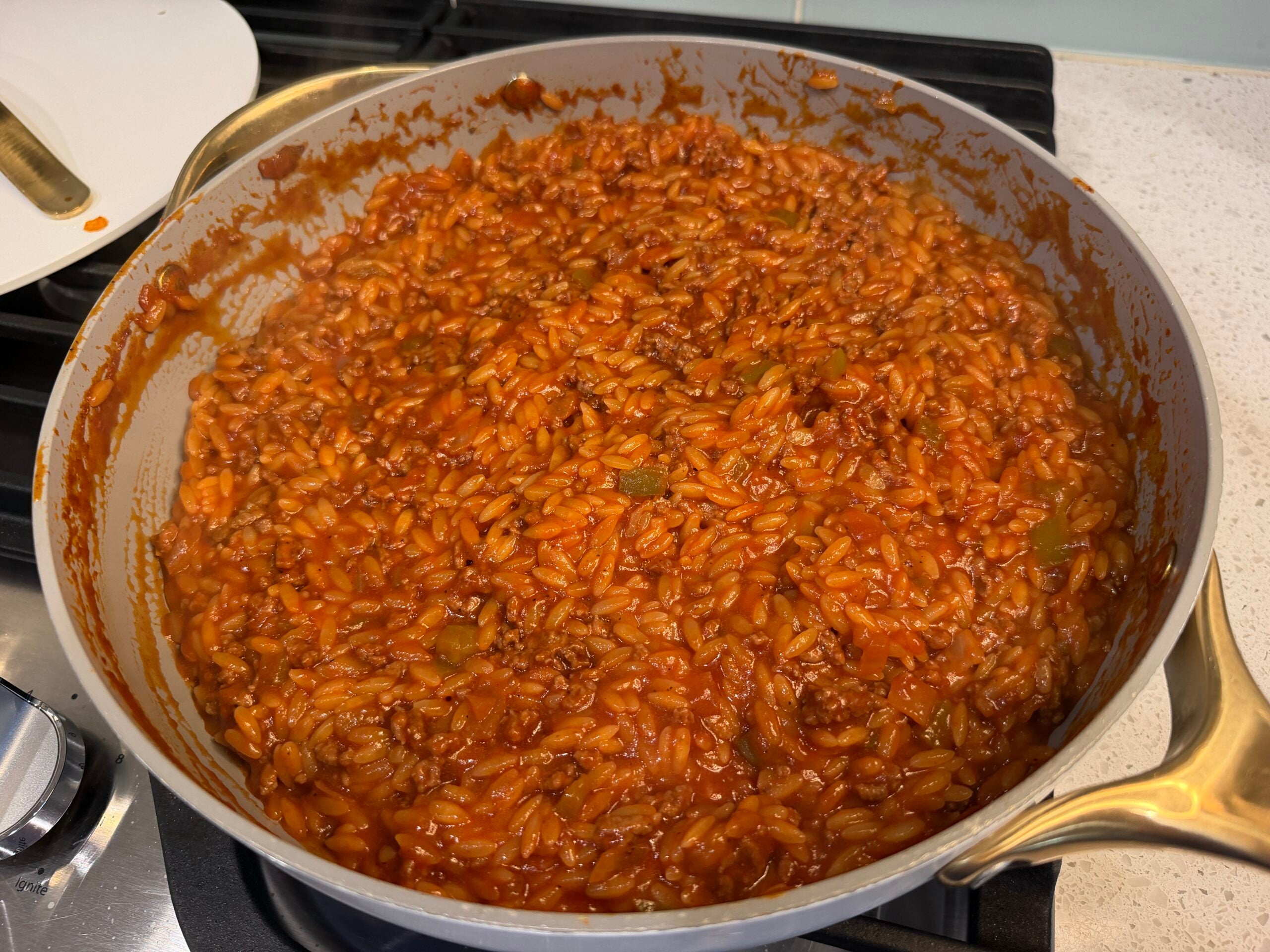 Orzo simmering in sloppy joe sauce in a skillet